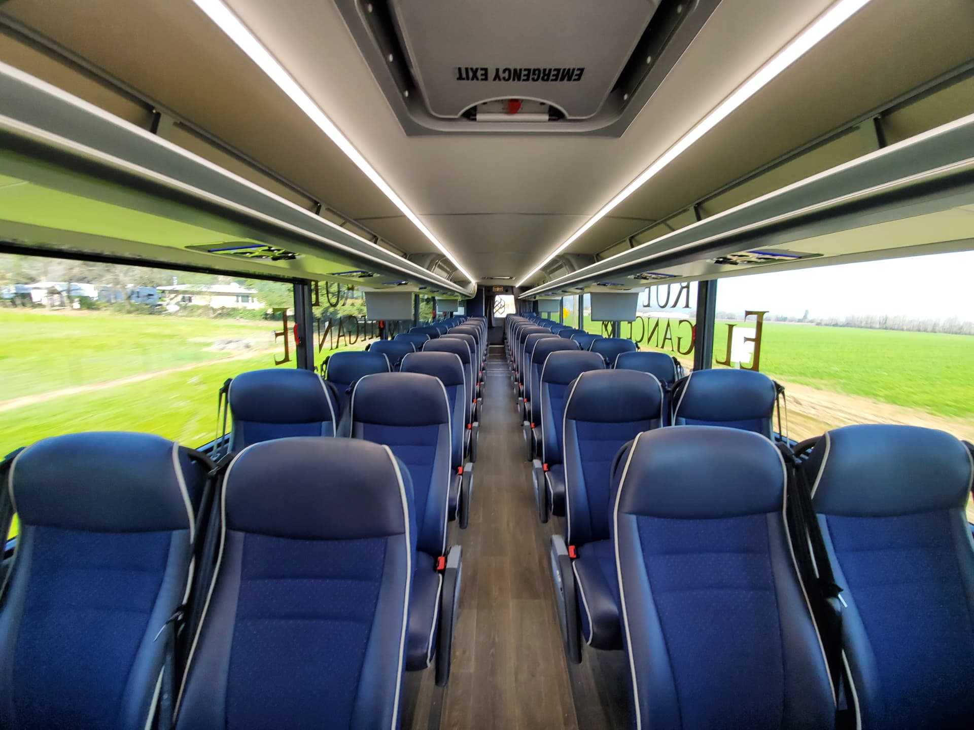 Charter coach interior Interior aisle of a True Elegance charter coach with blue reclining seats and overhead luggage racks