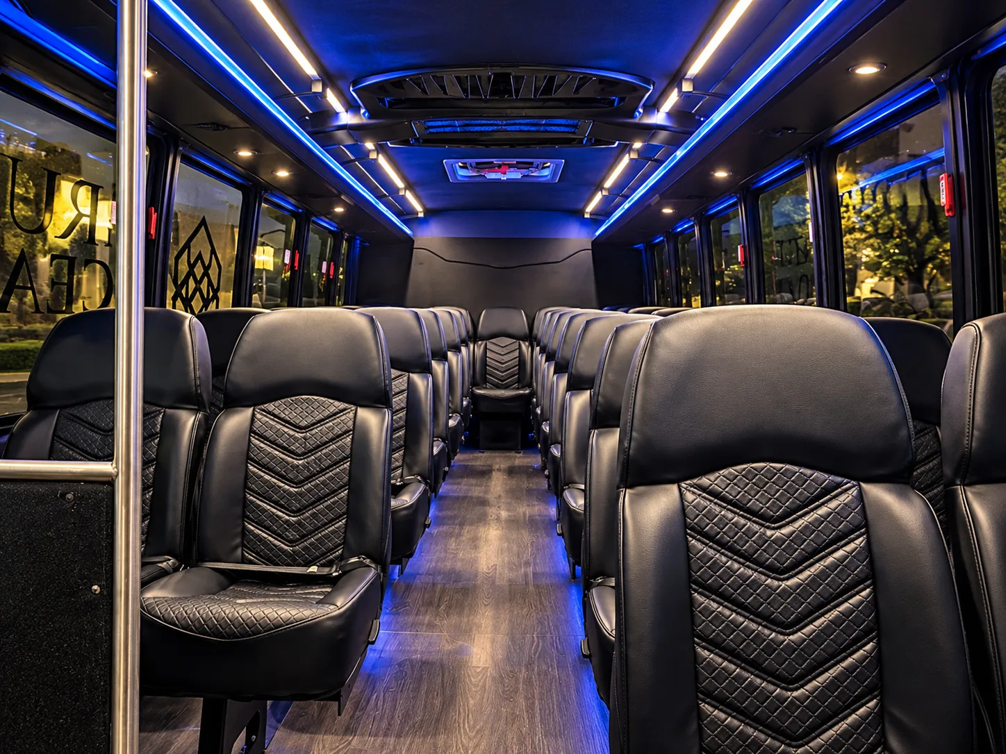 27-passenger shuttle bus interior — Tri-Valley, CA Interior of a True Elegance 27-passenger shuttle bus with black quilted leather seats, seatbelts and blue LED lighting, available for shuttle bus and charter service in Tri-Valley, California